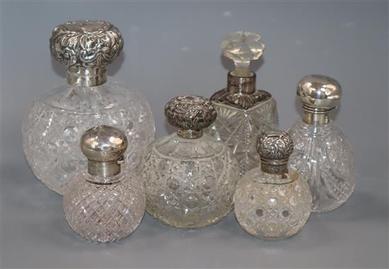 A large late Victorian silver mounted cut glass scent bottle and five other scent bottles.